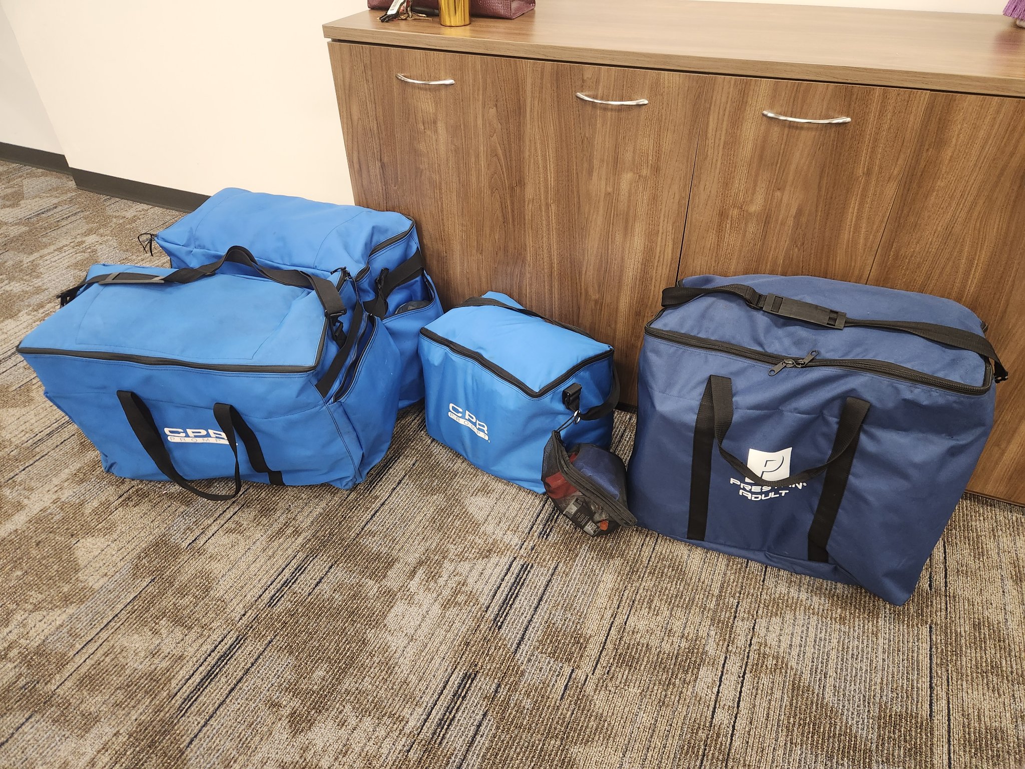 Define Rescue's mobile training kit — CPR Prompt and Prestan adult mannequin carry bags packed and ready to travel to a client's site